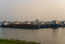 Aerial view of an inland freshwater port with docked cargo vessels along a river