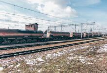 Long freight train moving along rail tracks through open countryside