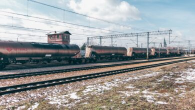 Long freight train moving along rail tracks through open countryside