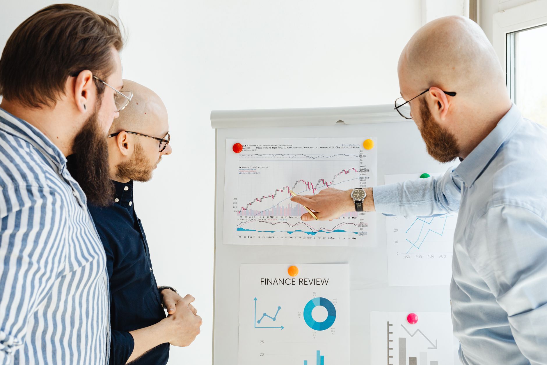 Financial professionals reviewing investment documents and data at a conference table