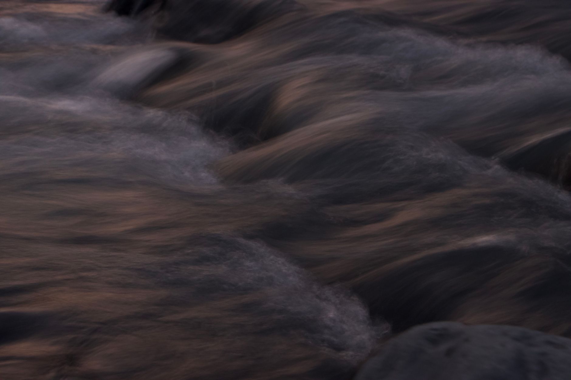 Wide river with strong current flowing through forested landscape