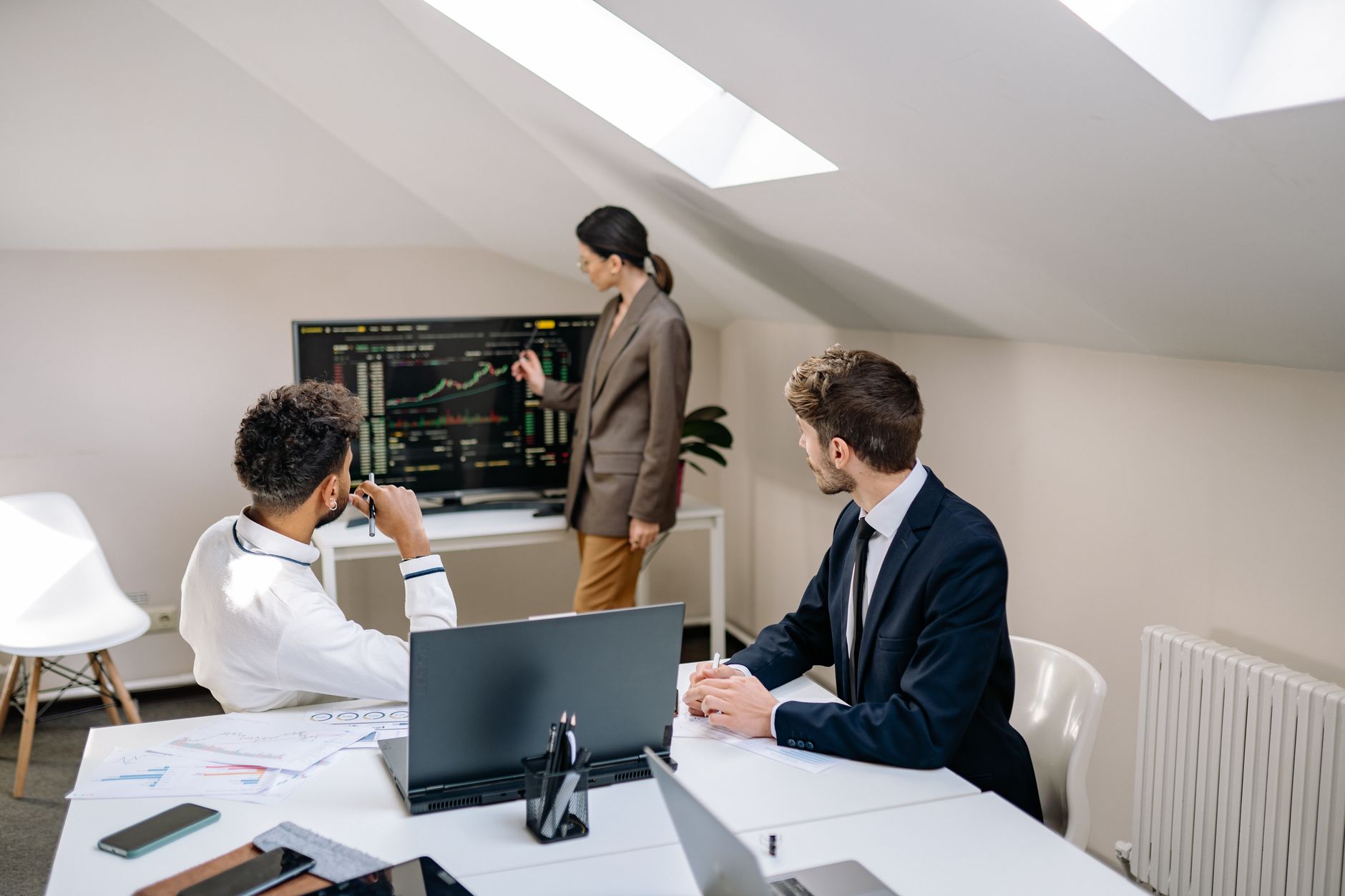 Investment professionals reviewing documents and data in a formal meeting room