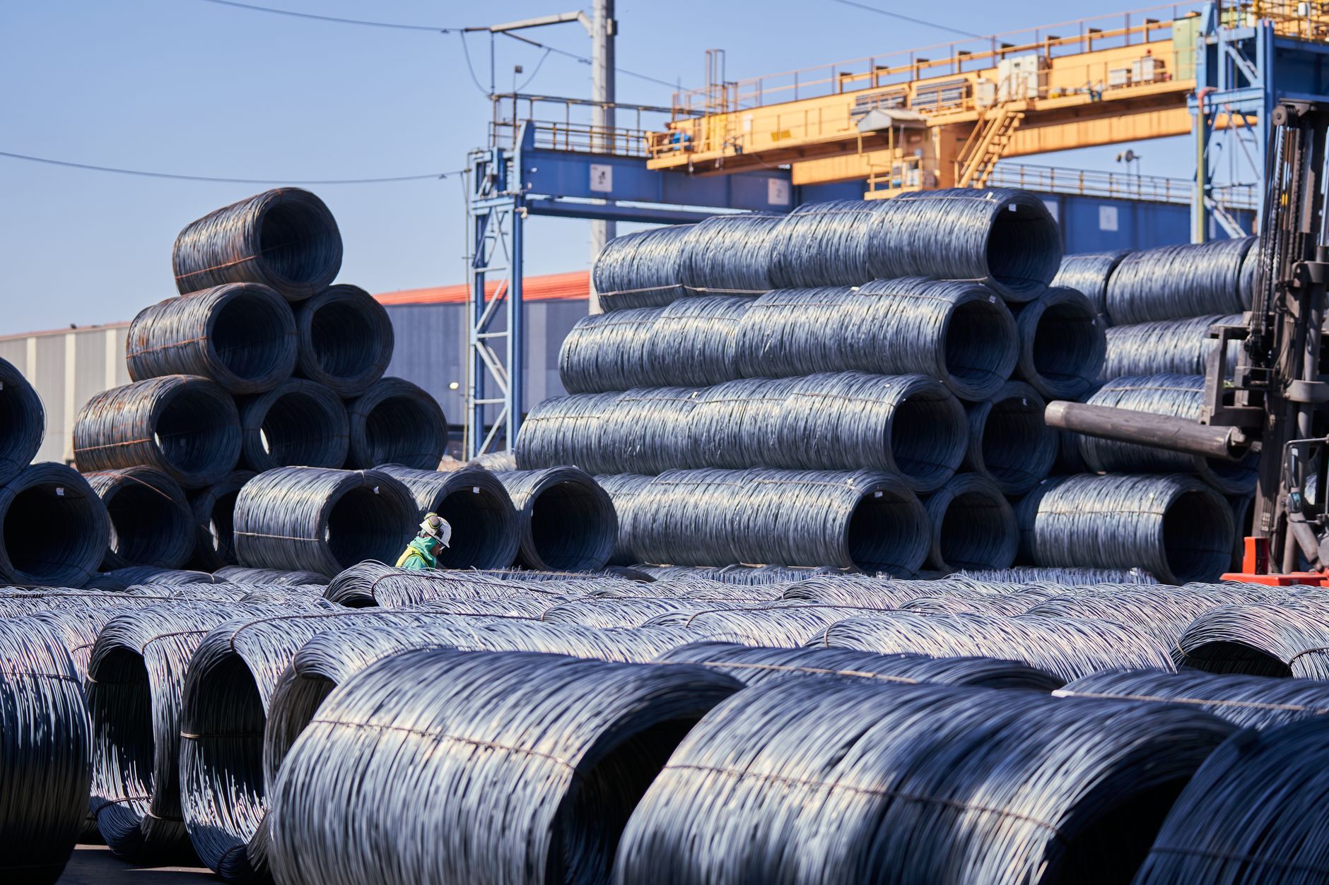 Coils of industrial copper wire stacked in a warehouse setting