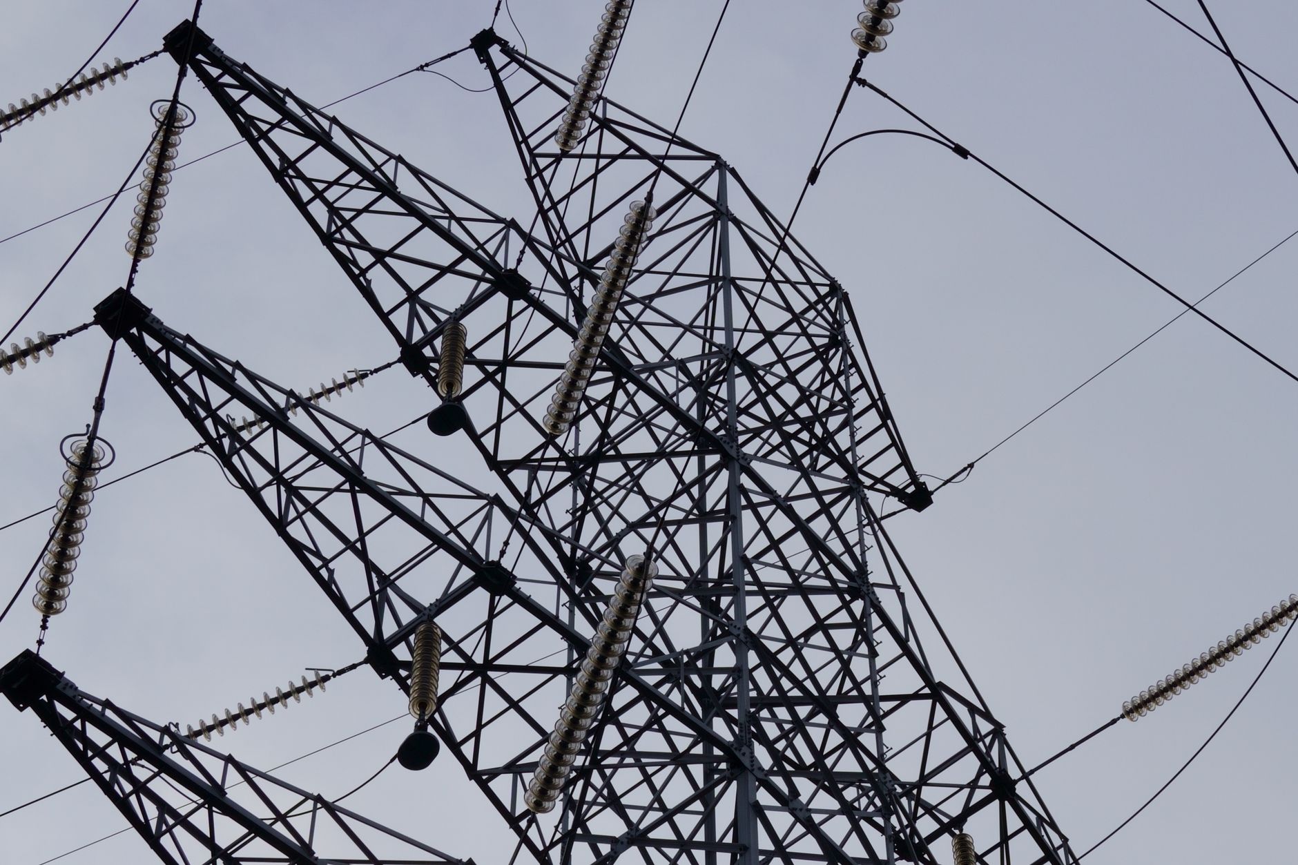 Steel electricity transmission tower against a blue sky in an open landscape