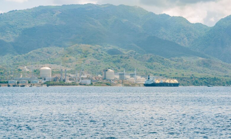 Large liquefied natural gas terminal with storage tanks and docking infrastructure along a waterway