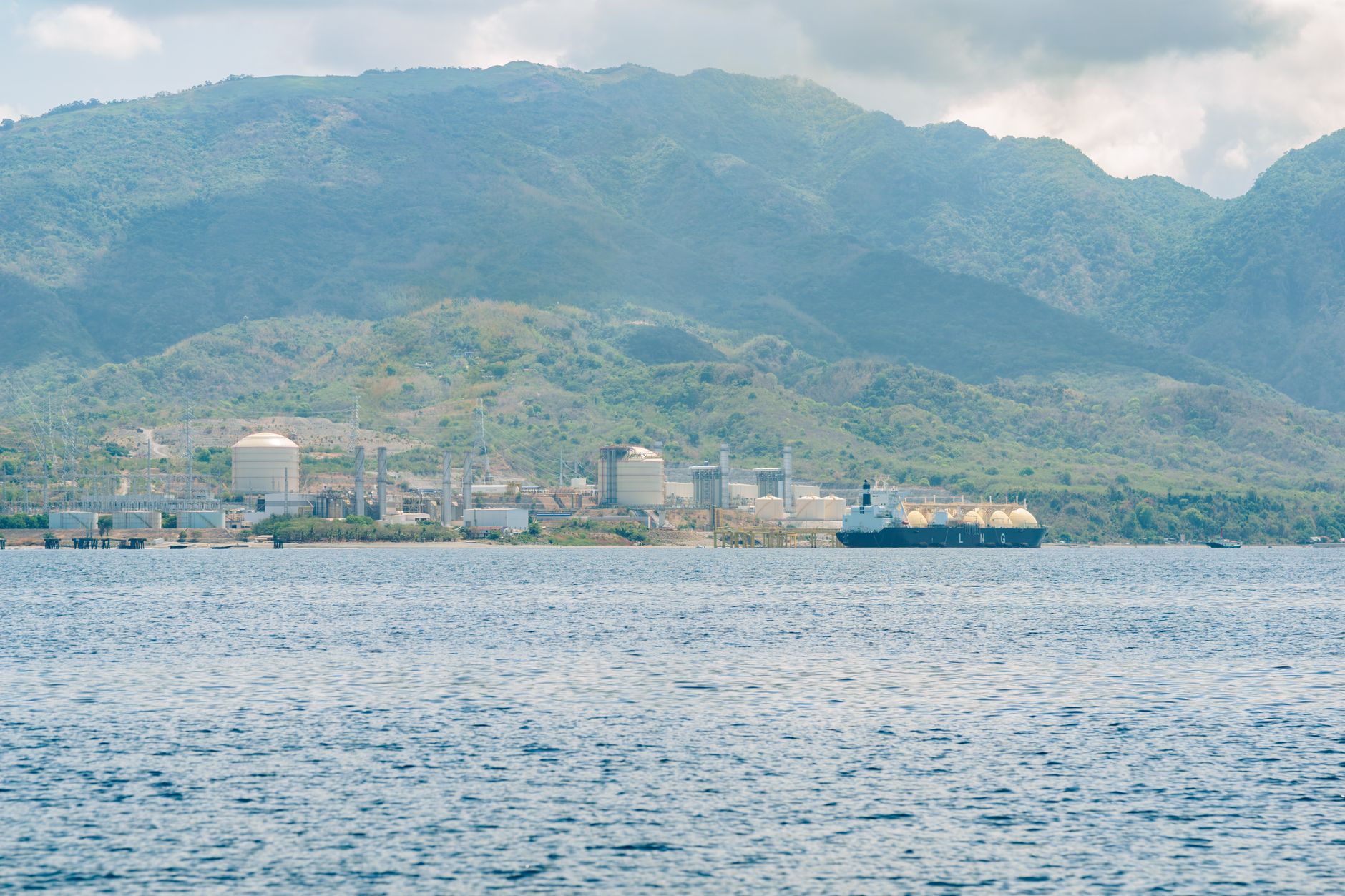 Large liquefied natural gas terminal with storage tanks and docking infrastructure along a waterway