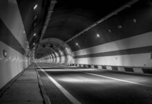 A long illuminated road tunnel with traffic flowing through it