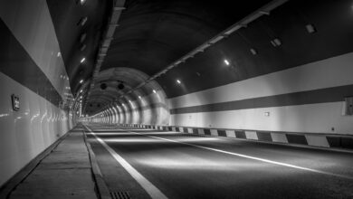 A long illuminated road tunnel with traffic flowing through it