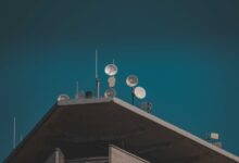 Large satellite dish arrays at a remote ground station facility pointing toward the sky