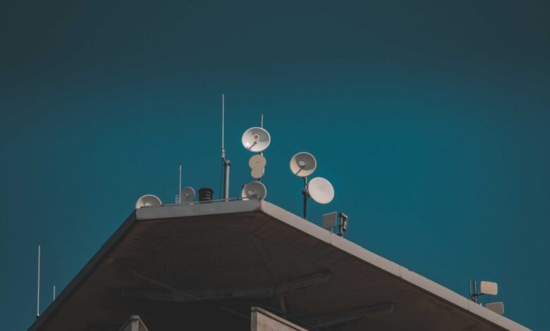 Large satellite dish arrays at a remote ground station facility pointing toward the sky