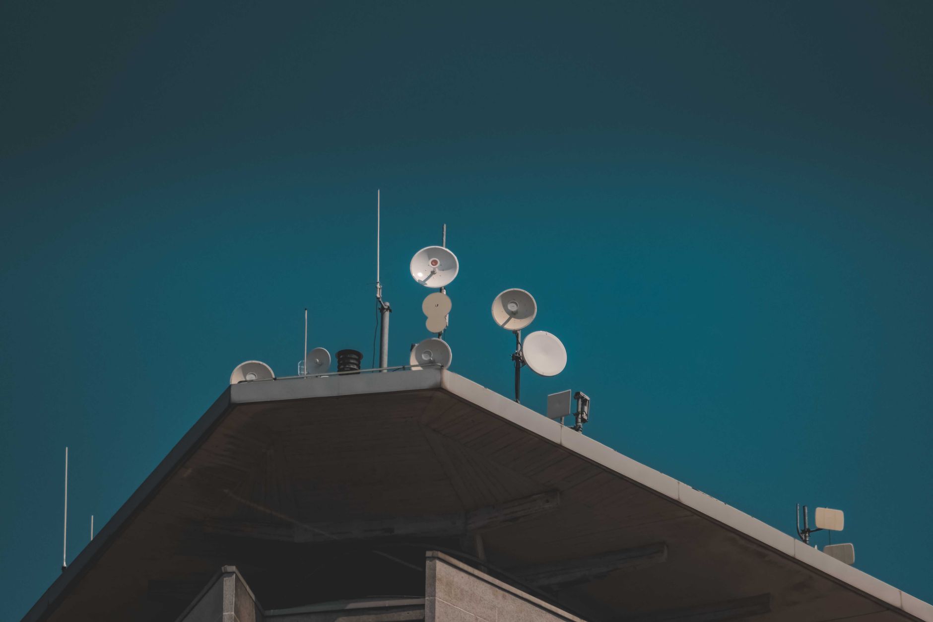 Large satellite dish arrays at a remote ground station facility pointing toward the sky