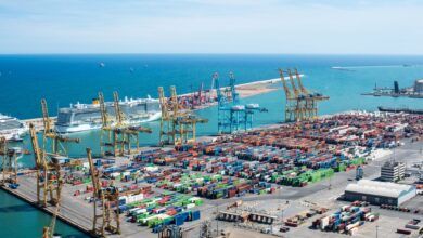 Aerial view of a large commercial cargo port with container ships and shipping channels