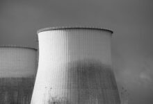 Aerial view of a nuclear facility with cooling towers and surrounding landscape
