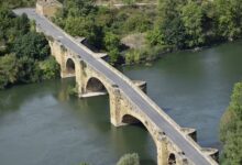 Aerial view of a large urban bridge spanning a river, representing infrastructure investment