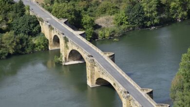 Aerial view of a large urban bridge spanning a river, representing infrastructure investment