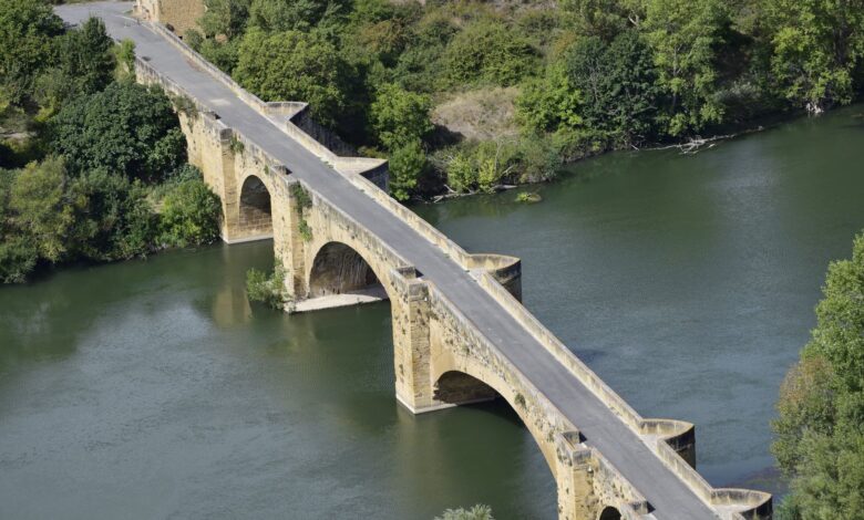 Aerial view of a large urban bridge spanning a river, representing infrastructure investment