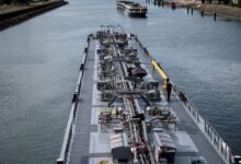 A cargo barge traveling through an industrial freight canal