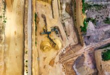 Aerial view of an active quarry operation with water pooling at the base