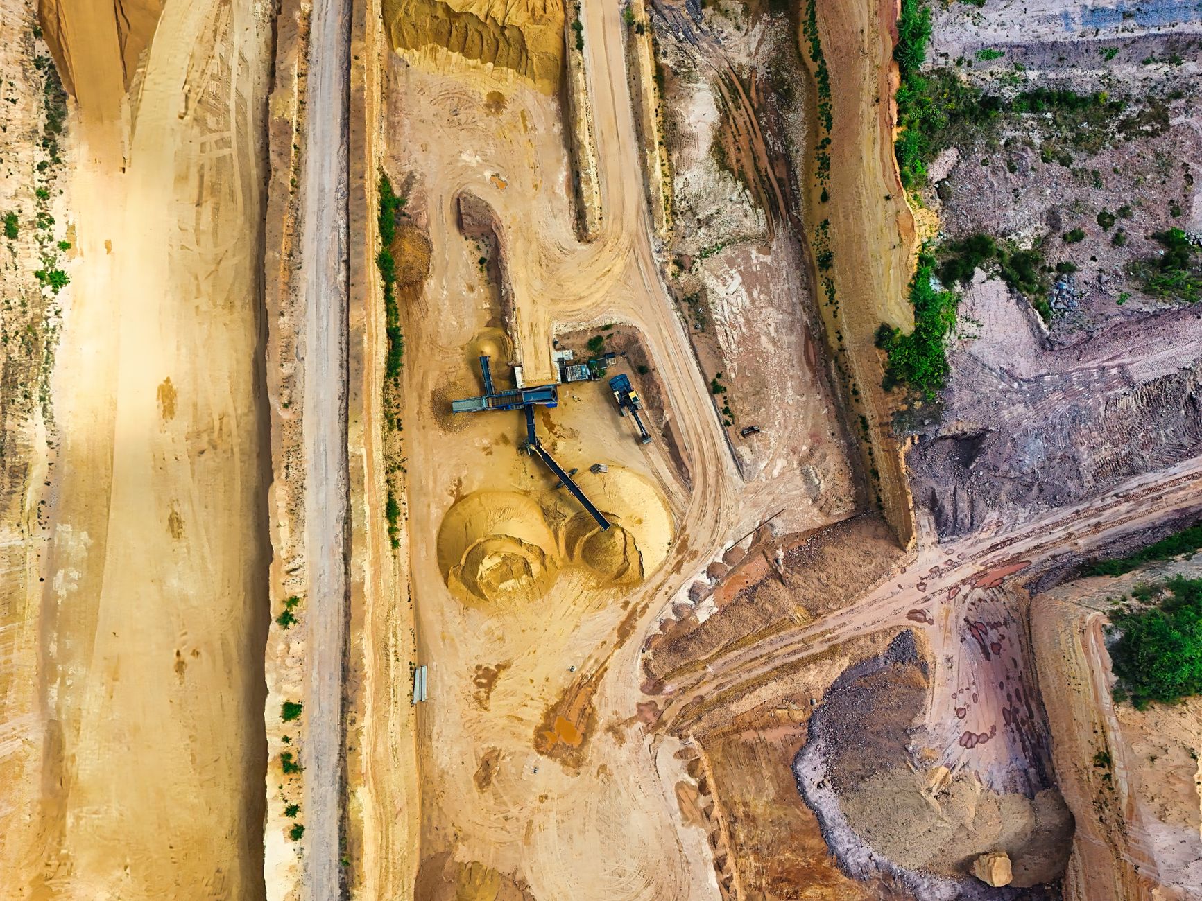 Aerial view of an active quarry operation with water pooling at the base
