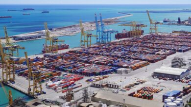 Large industrial export terminal with storage tanks and shipping berths along a coastal port