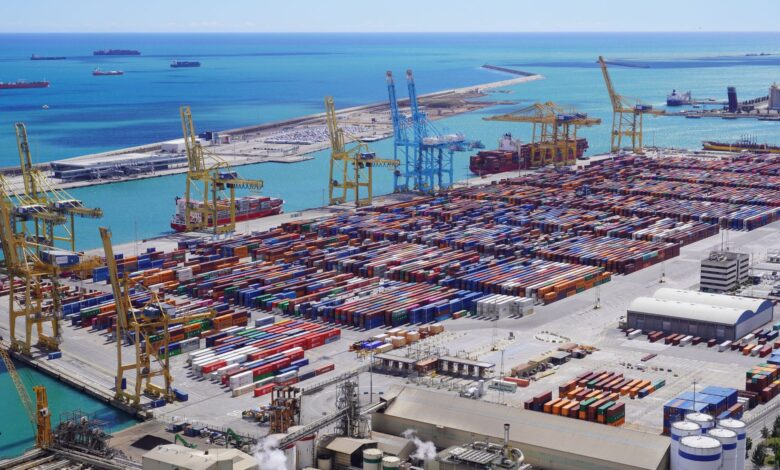 Large industrial export terminal with storage tanks and shipping berths along a coastal port