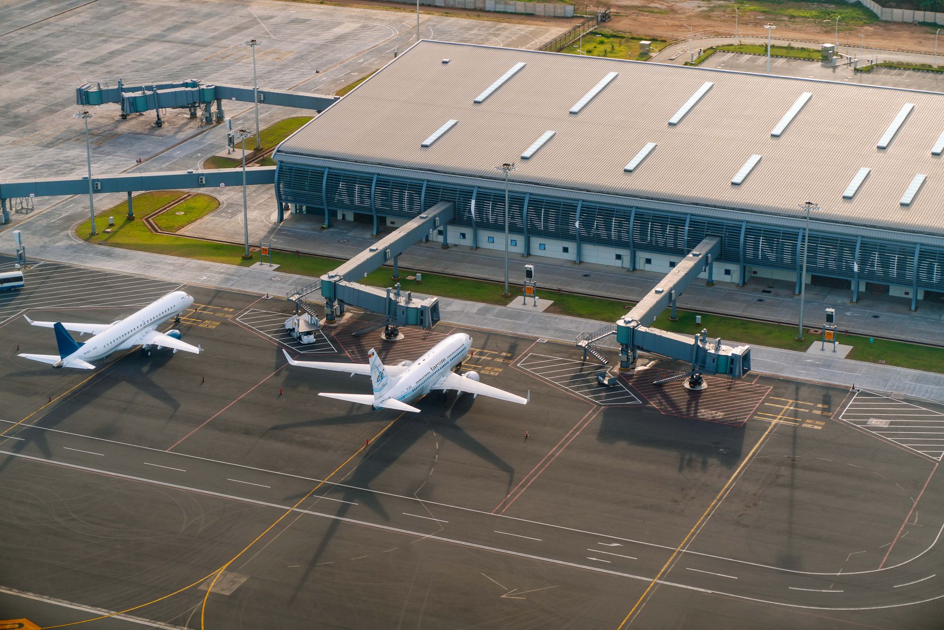 Aerial view of airport tarmac with aircraft parked at gates
