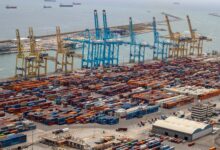 Aerial view of a large container seaport with multiple berths and cargo ships