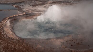 Steam rising from a geothermal energy plant in an open landscape
