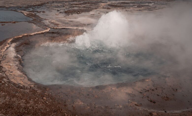 Steam rising from a geothermal energy plant in an open landscape
