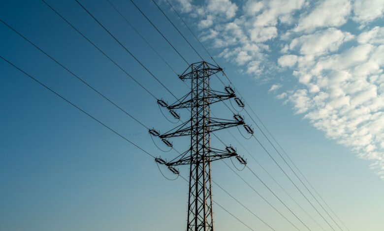 Aerial view of high-voltage electricity transmission lines crossing open land