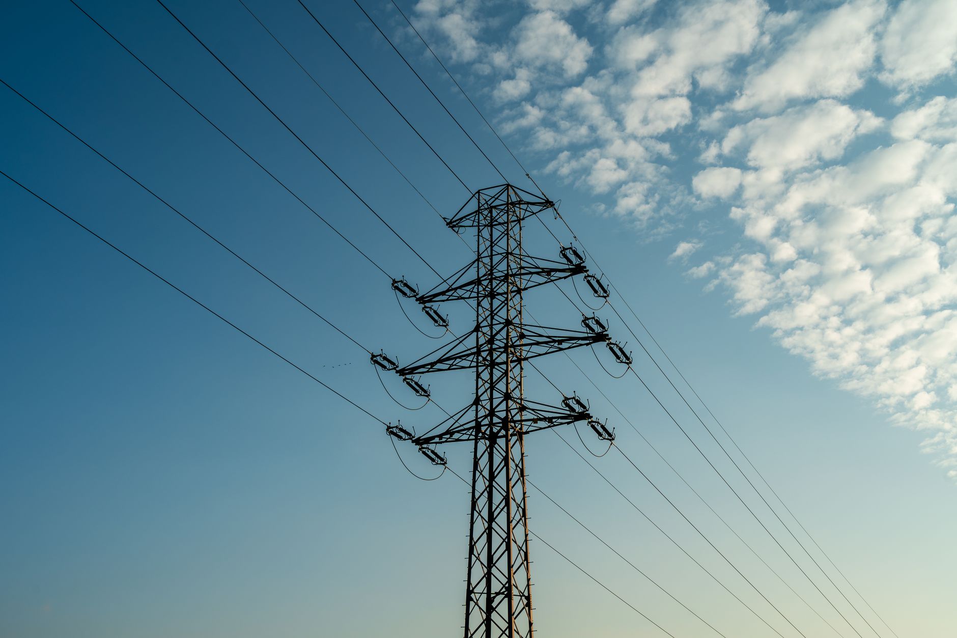 Aerial view of high-voltage electricity transmission lines crossing open land