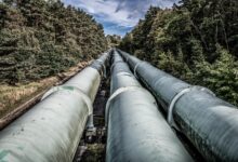 Industrial pipeline under construction across open land representing CO2 transport infrastructure
