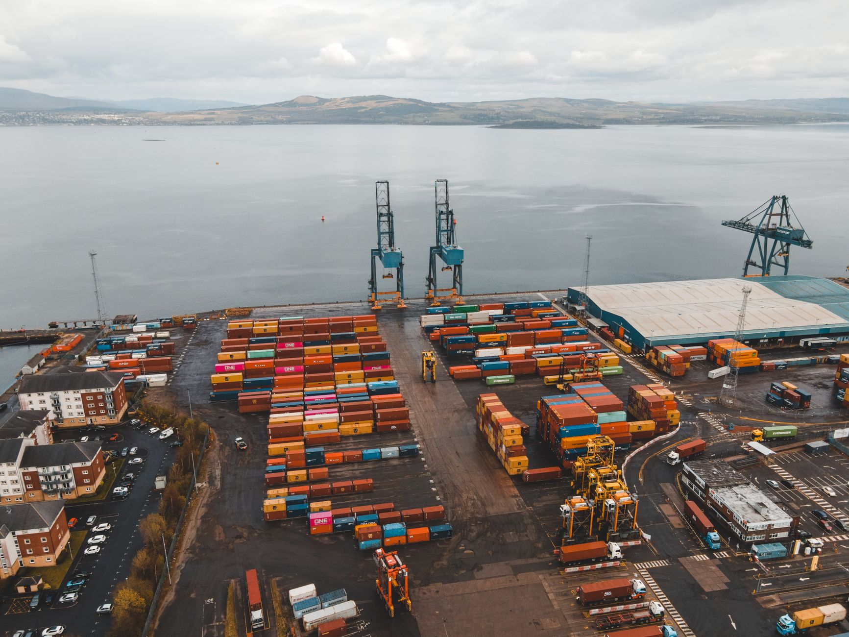 Rows of stacked shipping containers at a commercial seaport terminal