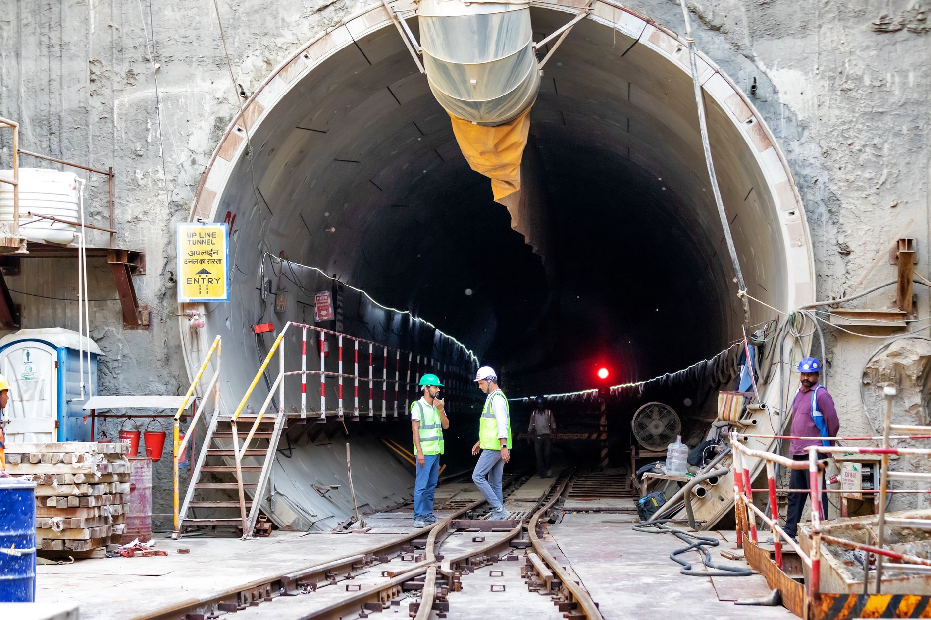Workers installing underground conduit infrastructure along a utility corridor