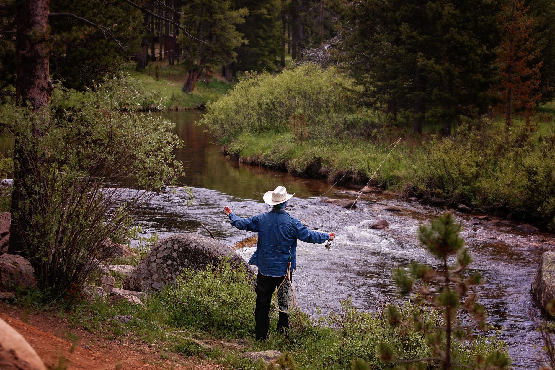 Angler fly fishing on a pristine mountain stream illustrating premium recreational fishing access