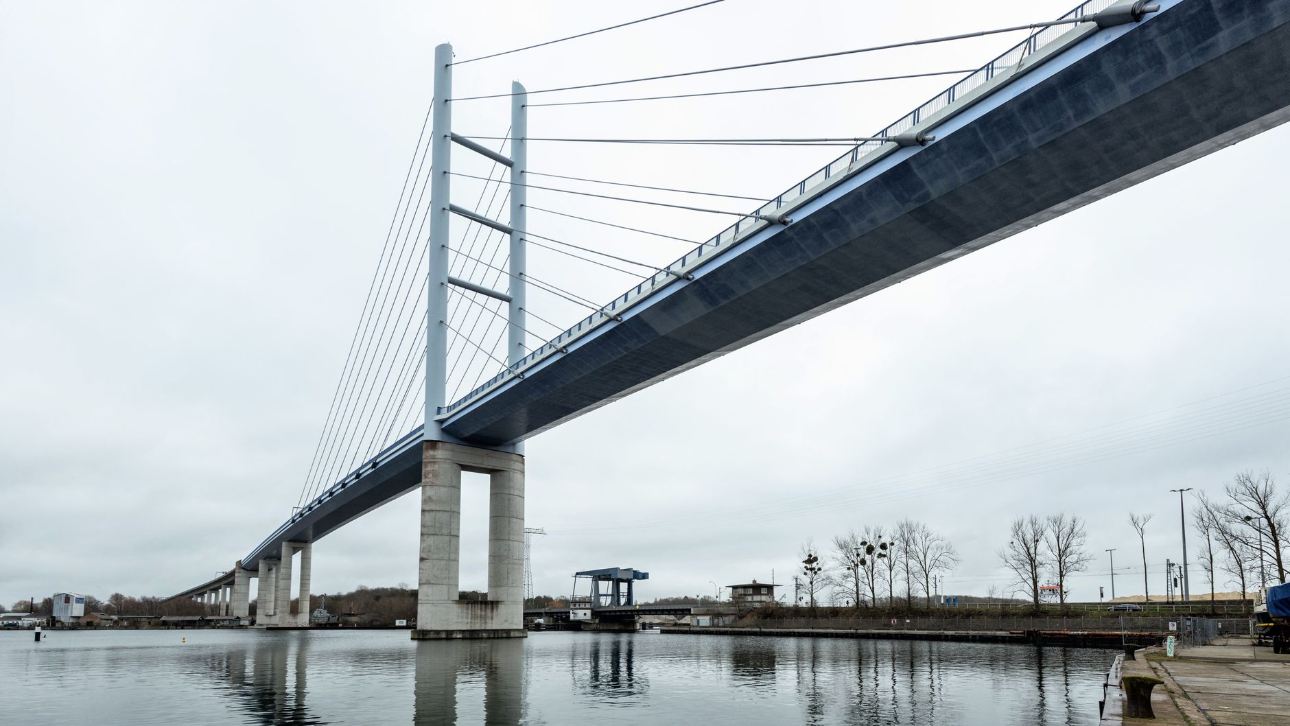 Wide-angle view of a large urban bridge spanning a waterway at dusk