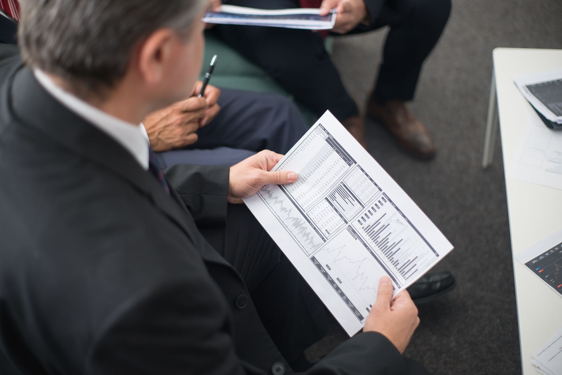 Institutional investors reviewing infrastructure documents at a conference table