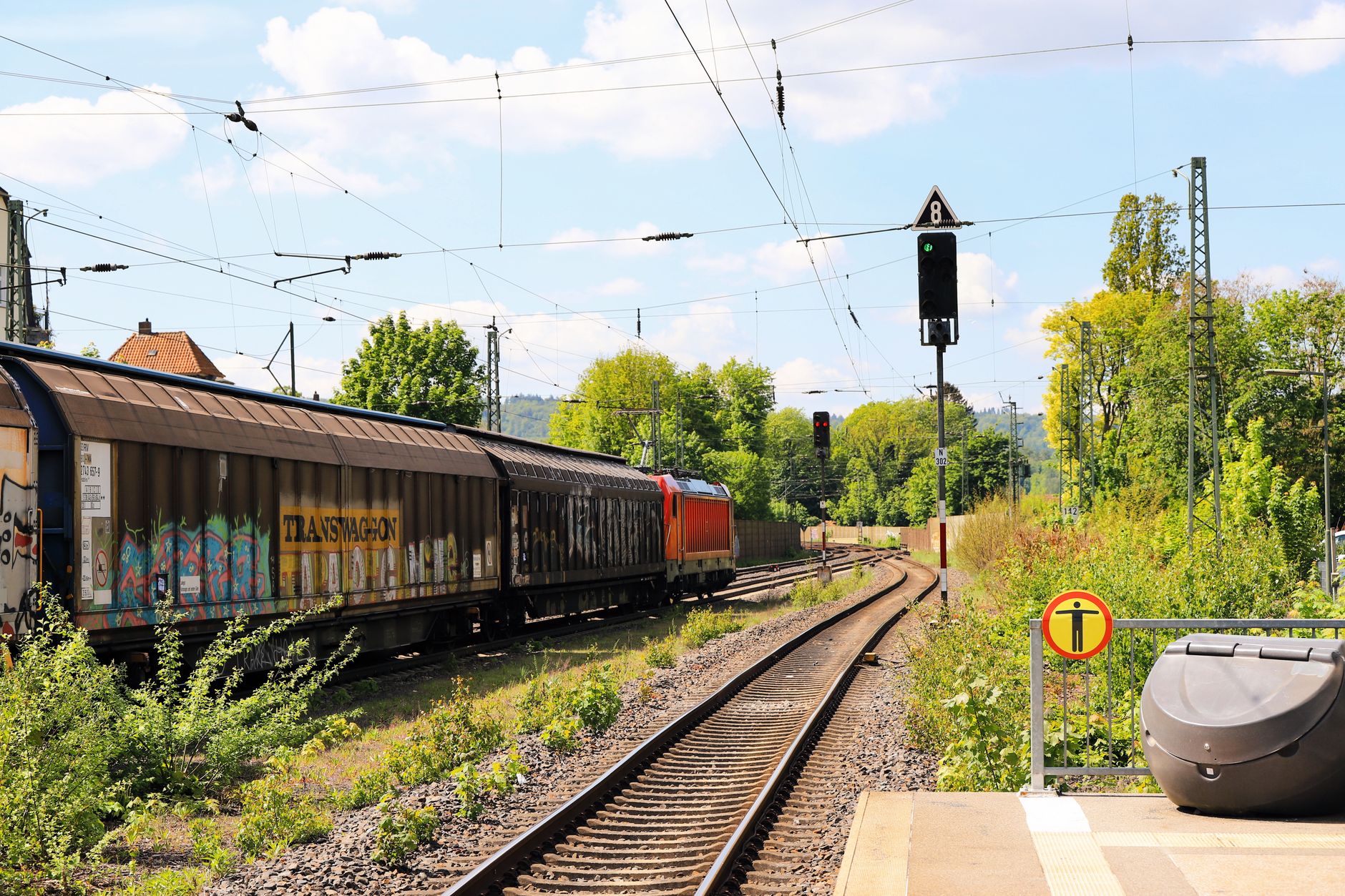 Long stretch of freight train tracks running through an industrial corridor