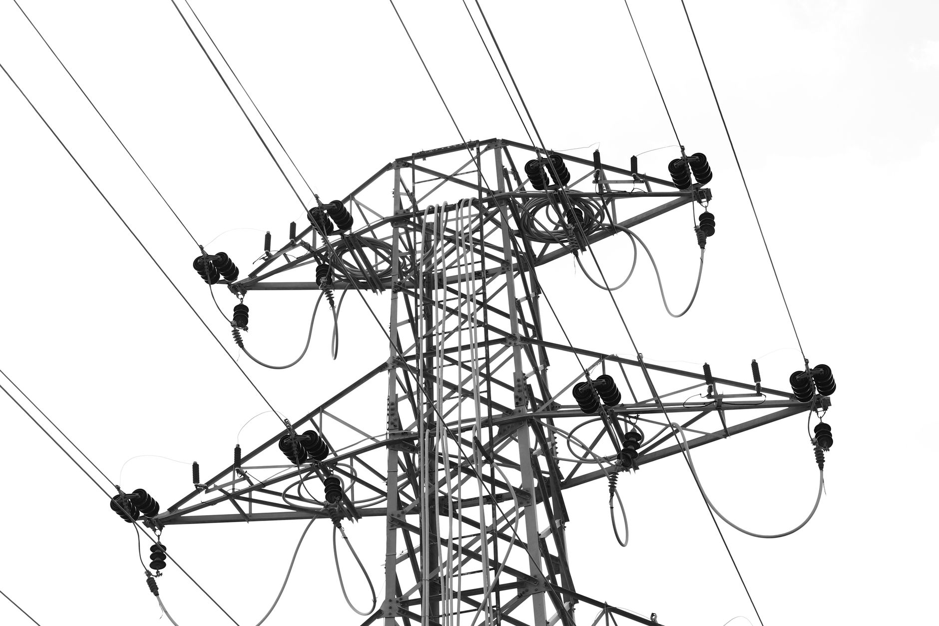 Steel electricity transmission tower against an overcast sky