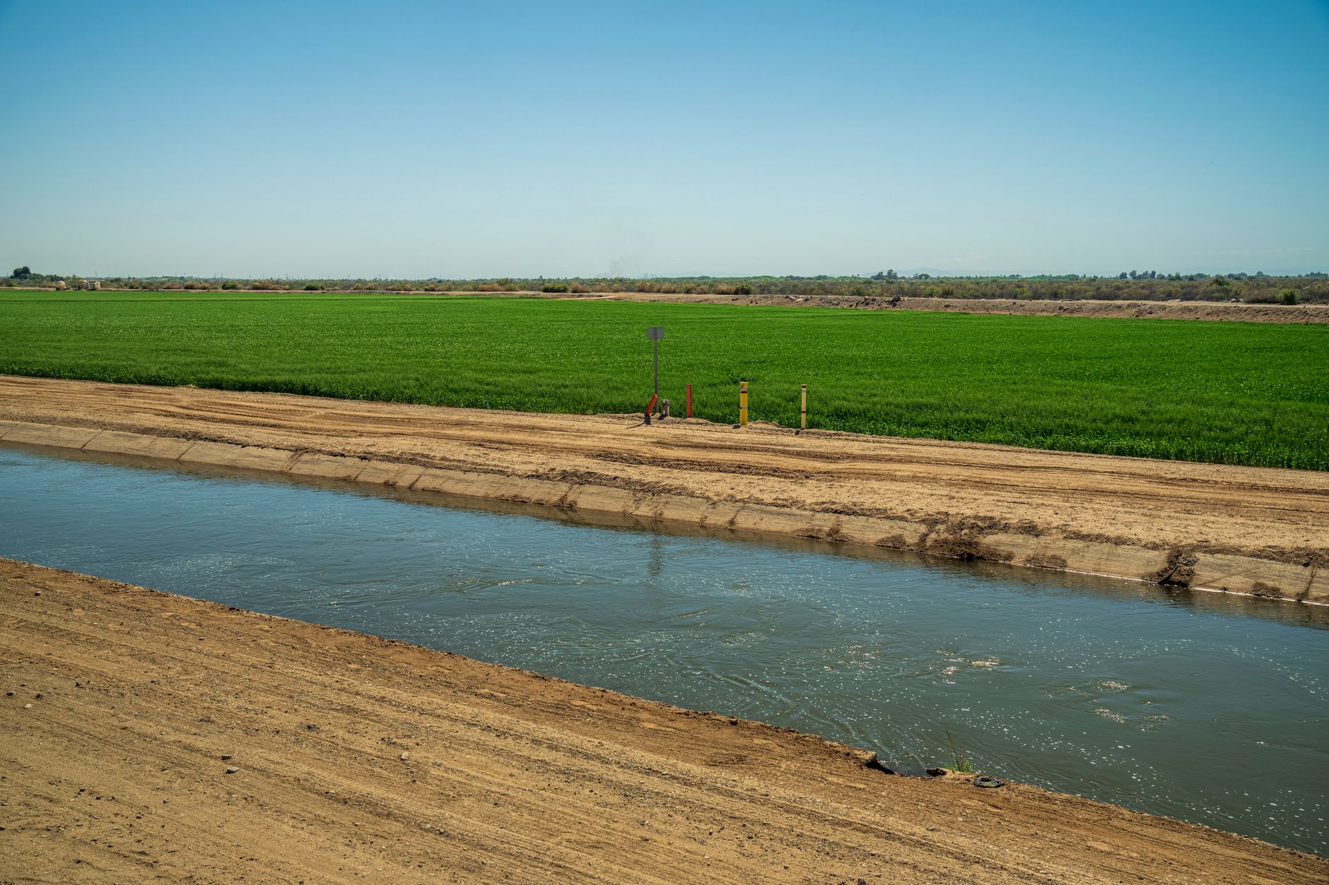 Water canal running through arid desert terrain in the American Southwest