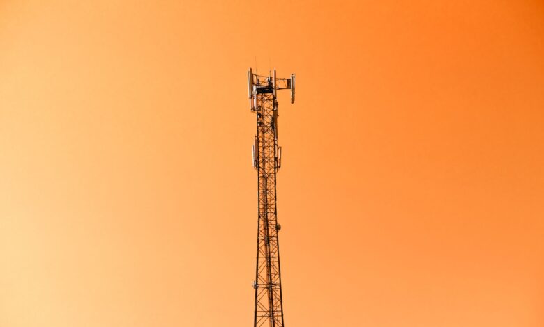 Wireless cell tower rising above open land representing ground lease infrastructure