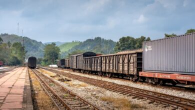Industrial freight railroad tracks stretching through a rural landscape