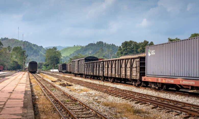 Industrial freight railroad tracks stretching through a rural landscape