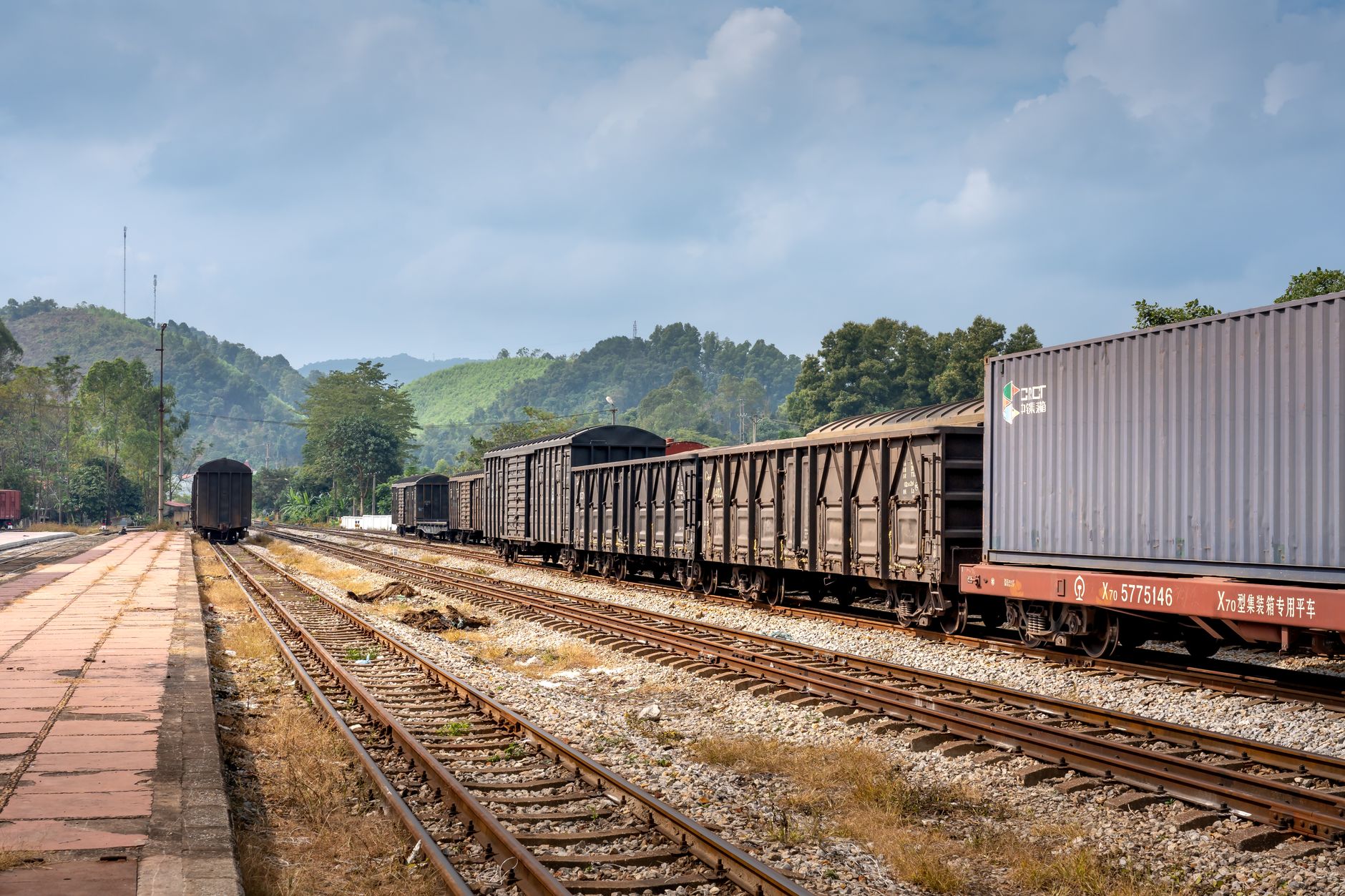 Industrial freight railroad tracks stretching through a rural landscape