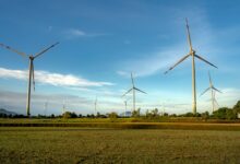 Wind turbines operating across a flat agricultural field representing wind energy infrastructure