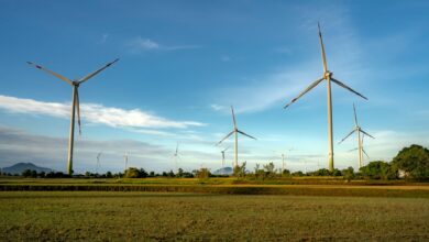 Wind turbines operating across a flat agricultural field representing wind energy infrastructure