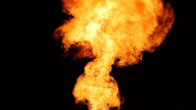 Gas flare burning at an oil production site at dusk