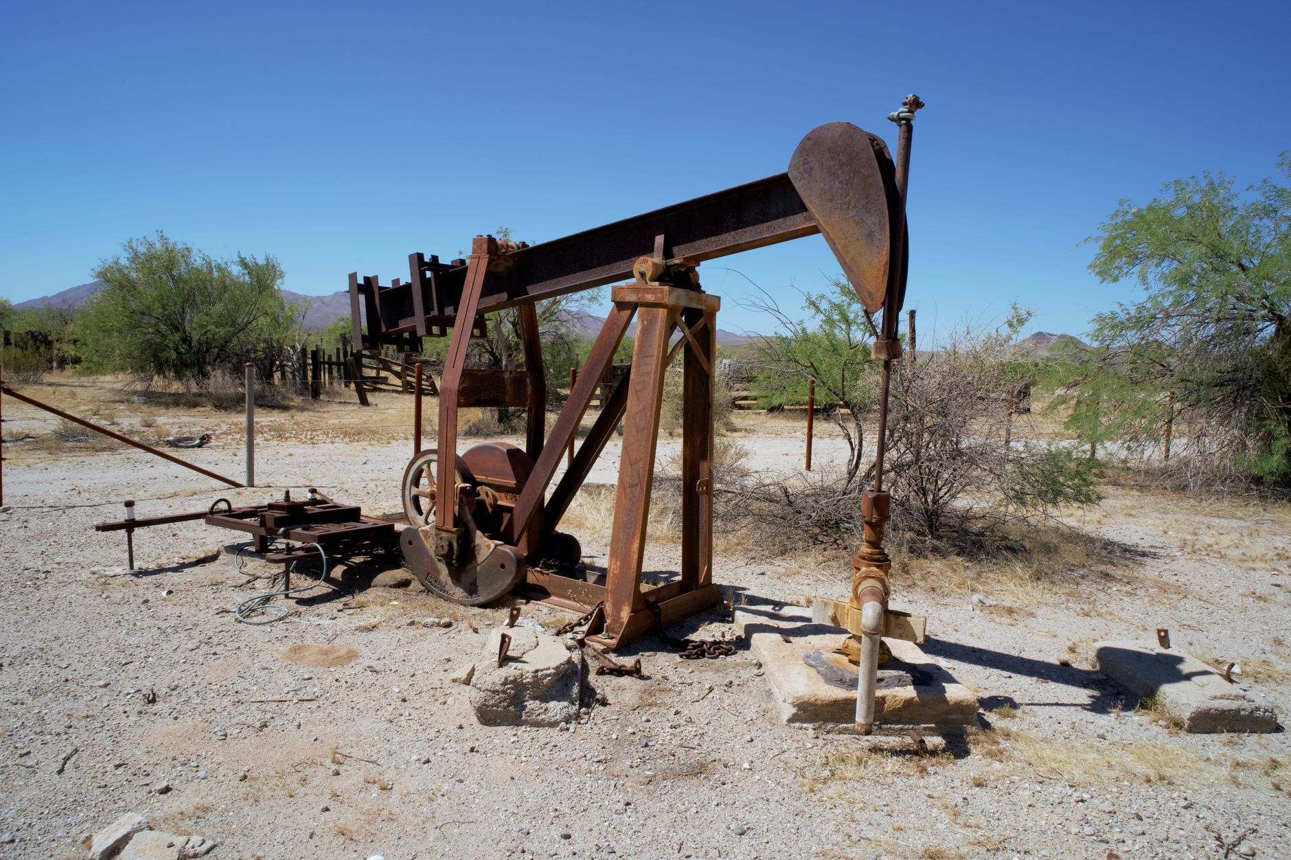 Oil well equipment in an open field representing oilfield infrastructure investment