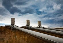 Large industrial pipeline stretching across open land representing energy transport infrastructure