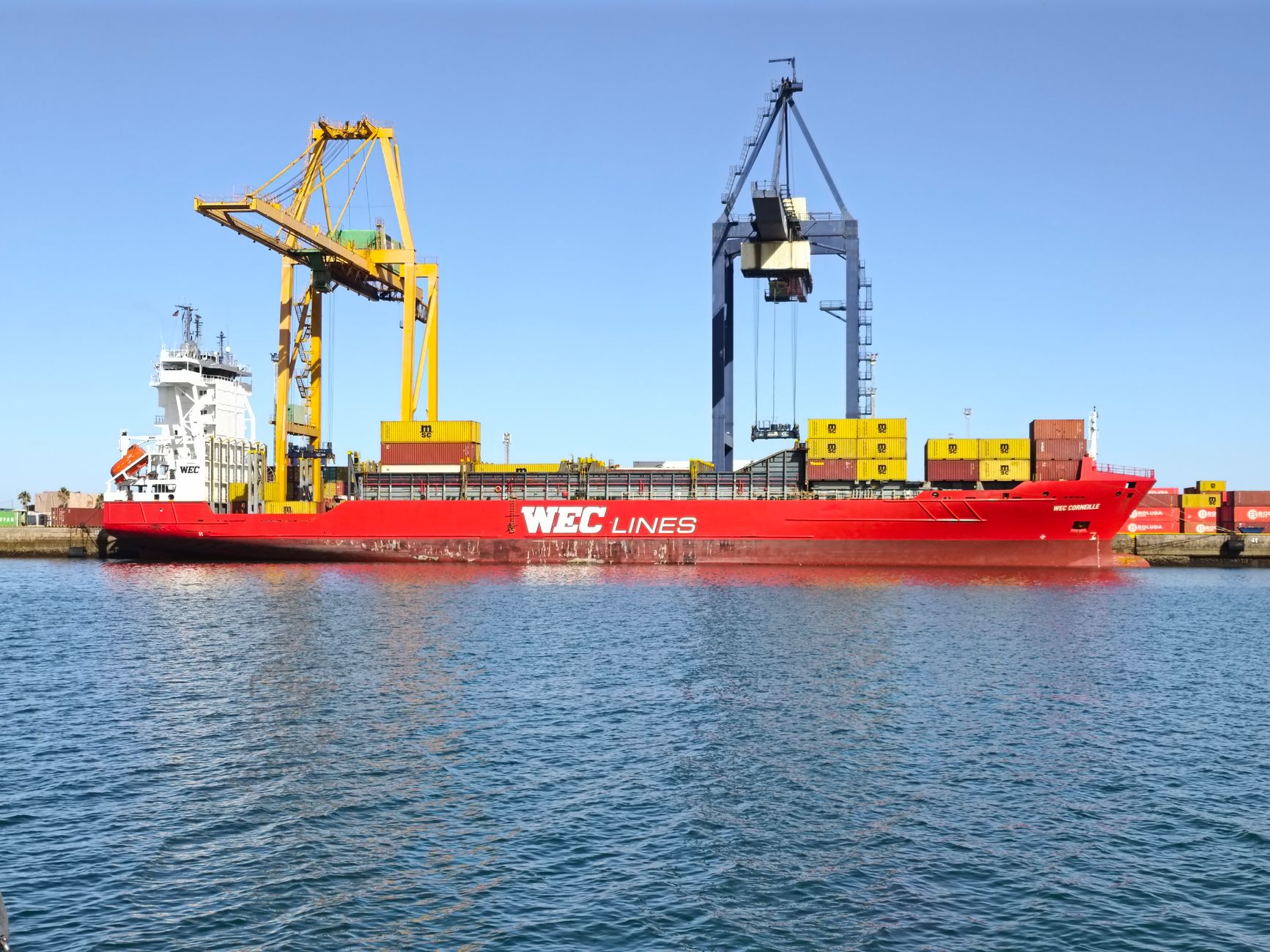 Large container ship moored at a commercial freight terminal dock
